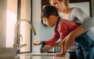 Mother and son using sink